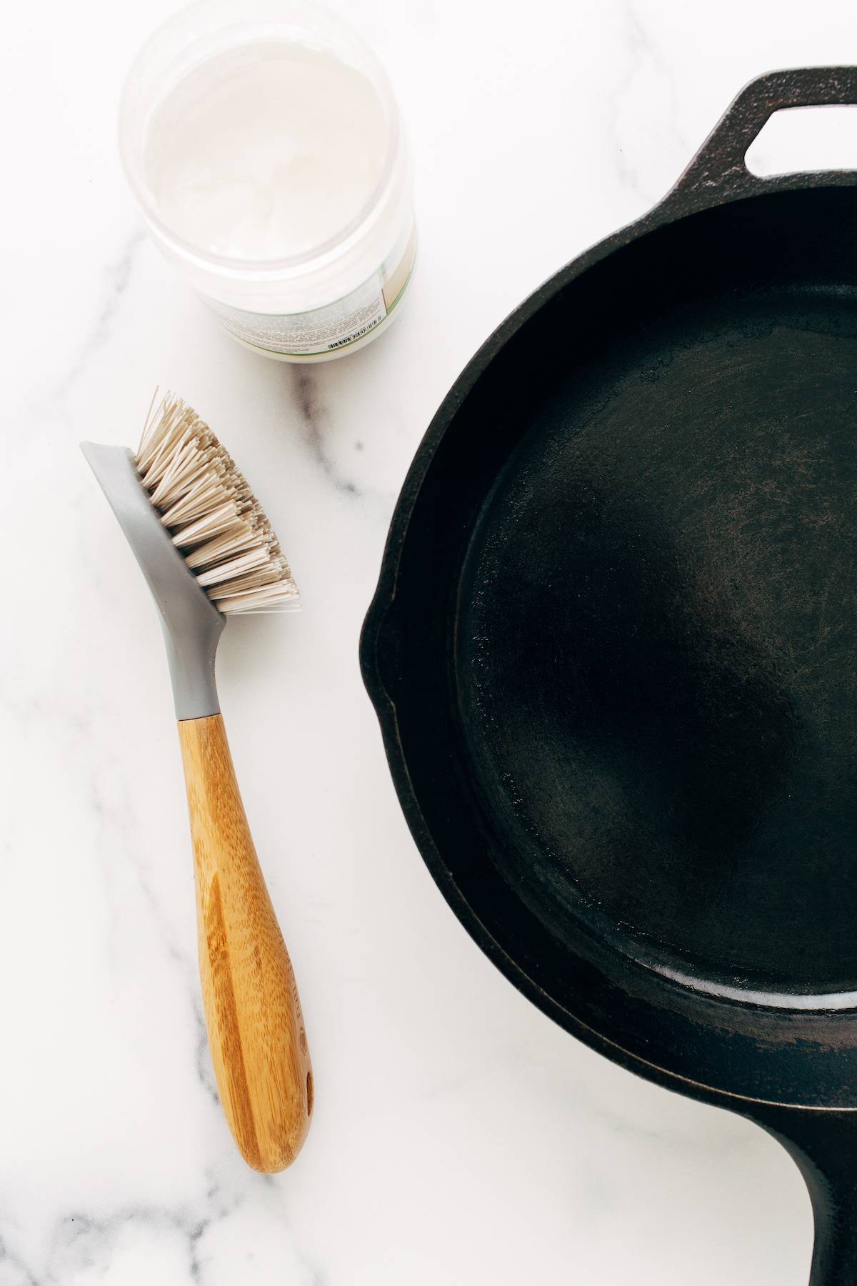 Pan made of cast iron with brush and coconut oil.