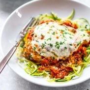 Healthy Chicken Parmesan on a plate with zoodles.