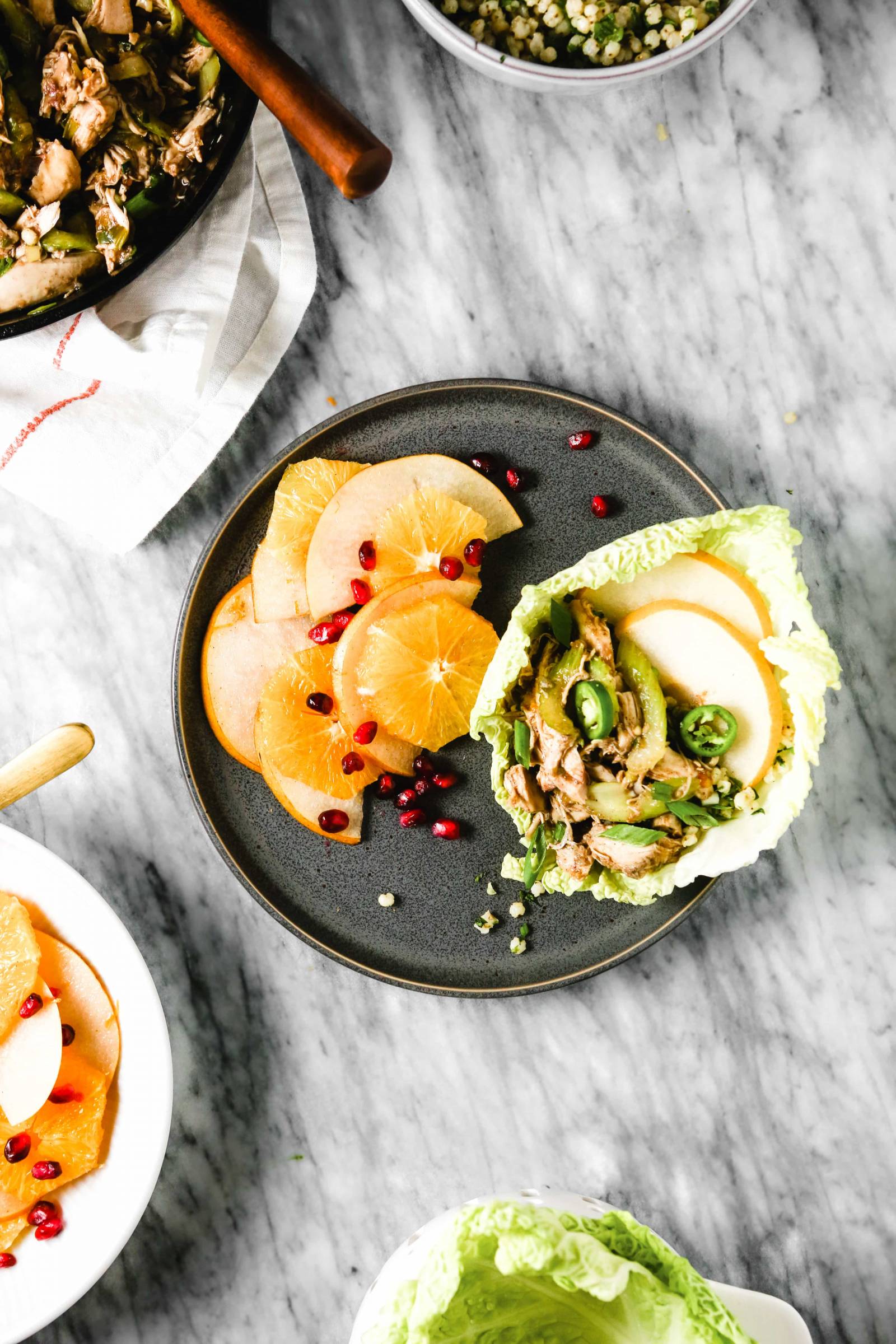 Chinese Turkey Lettuce Wraps on a plate with an orange apple salad