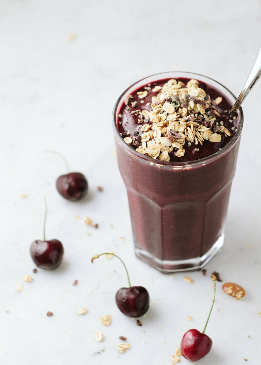 Chocolate Cherry Almond Smoothie in a glass with a spoon.
