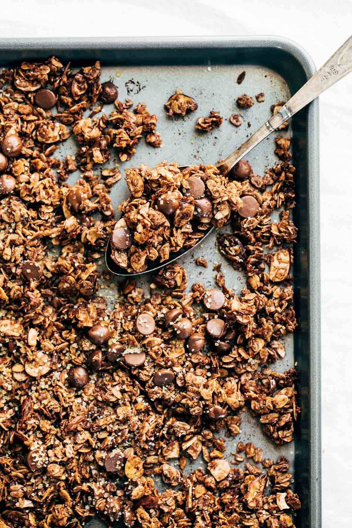 Chocolate Granola on a sheet pan and on a spoon.