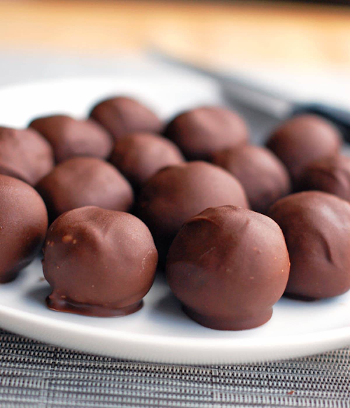 Triple chocolate party balls on a white plate.