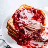 Eggnog French Toast on a plate with raspberry sauce.