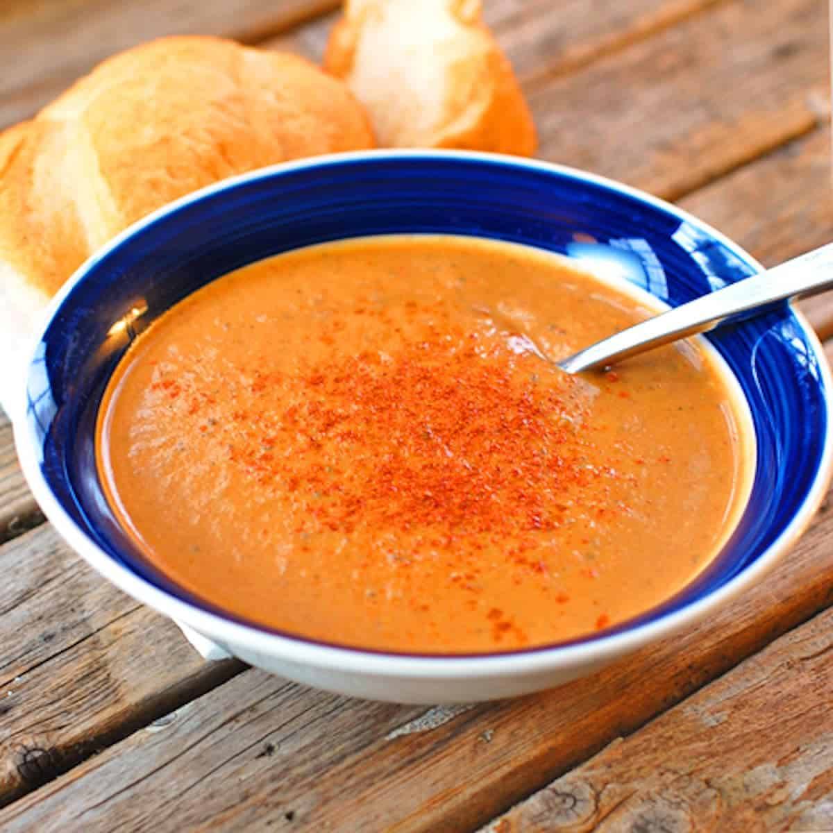 Pureed curry roasted red pepper and eggplant soup in a blue bowl.