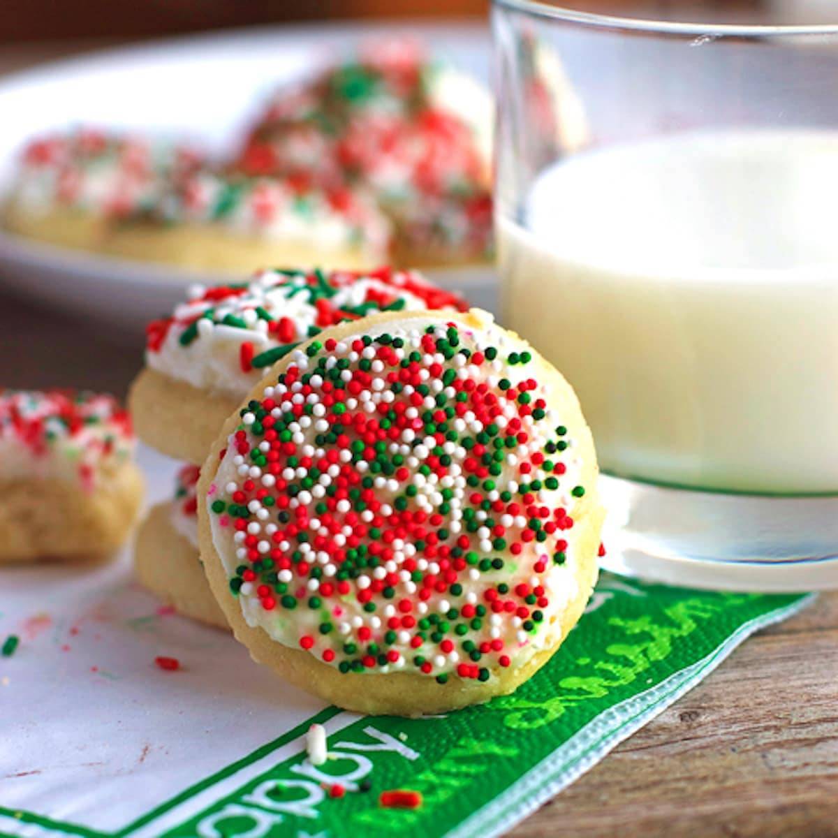 Fluffy sugar cookies are topped with a vanilla frosting and sprinkles. 