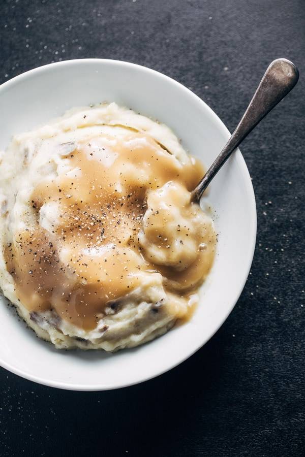 Garlic Mashed Potatoes in a bowl with gravy.