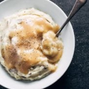 Garlic Mashed Potatoes in a bowl with gravy and a spoon.