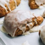 Maple Glazed Gingerbread Scones on parchment paper with glaze.