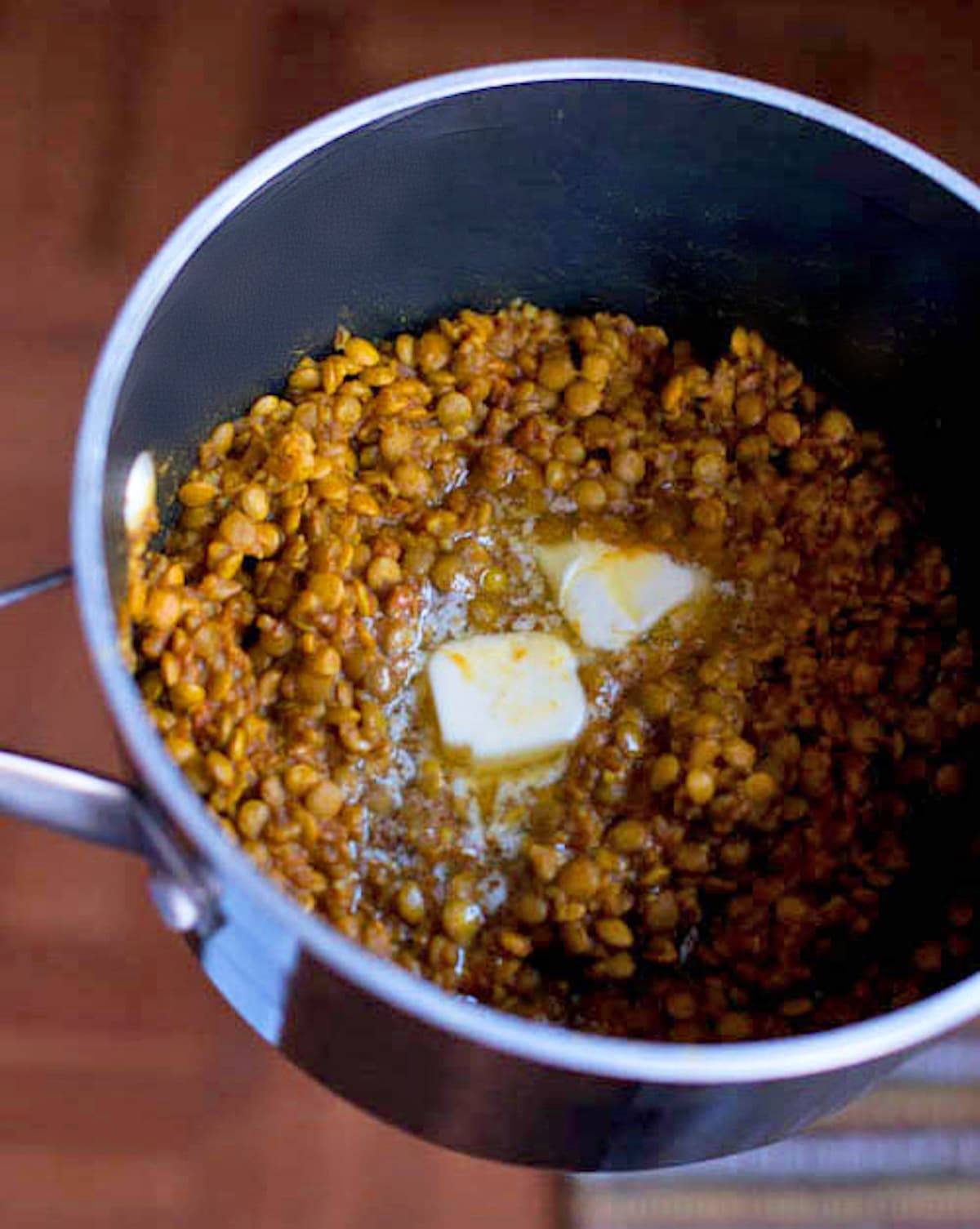 Coconut green curry lentils in a pan with butter.