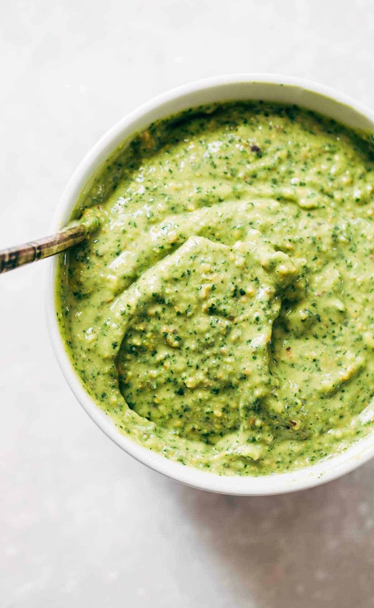 Magic green sauce in a bowl with a spoon.