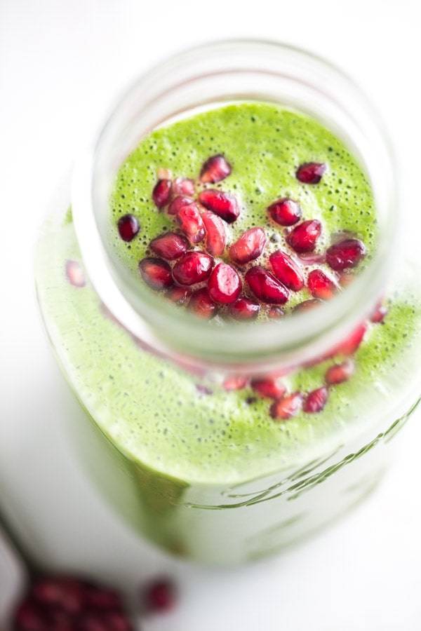 Green apple smoothie with pomegranate seeds.