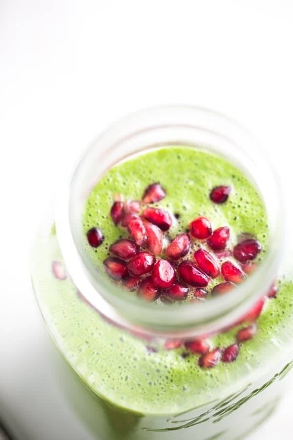 Green apple smoothie with pomegranate seeds.
