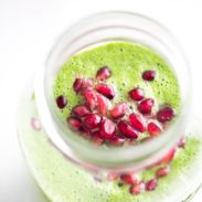 Holiday Detox Green Apple Smoothie in a jar with pomegranate seeds.