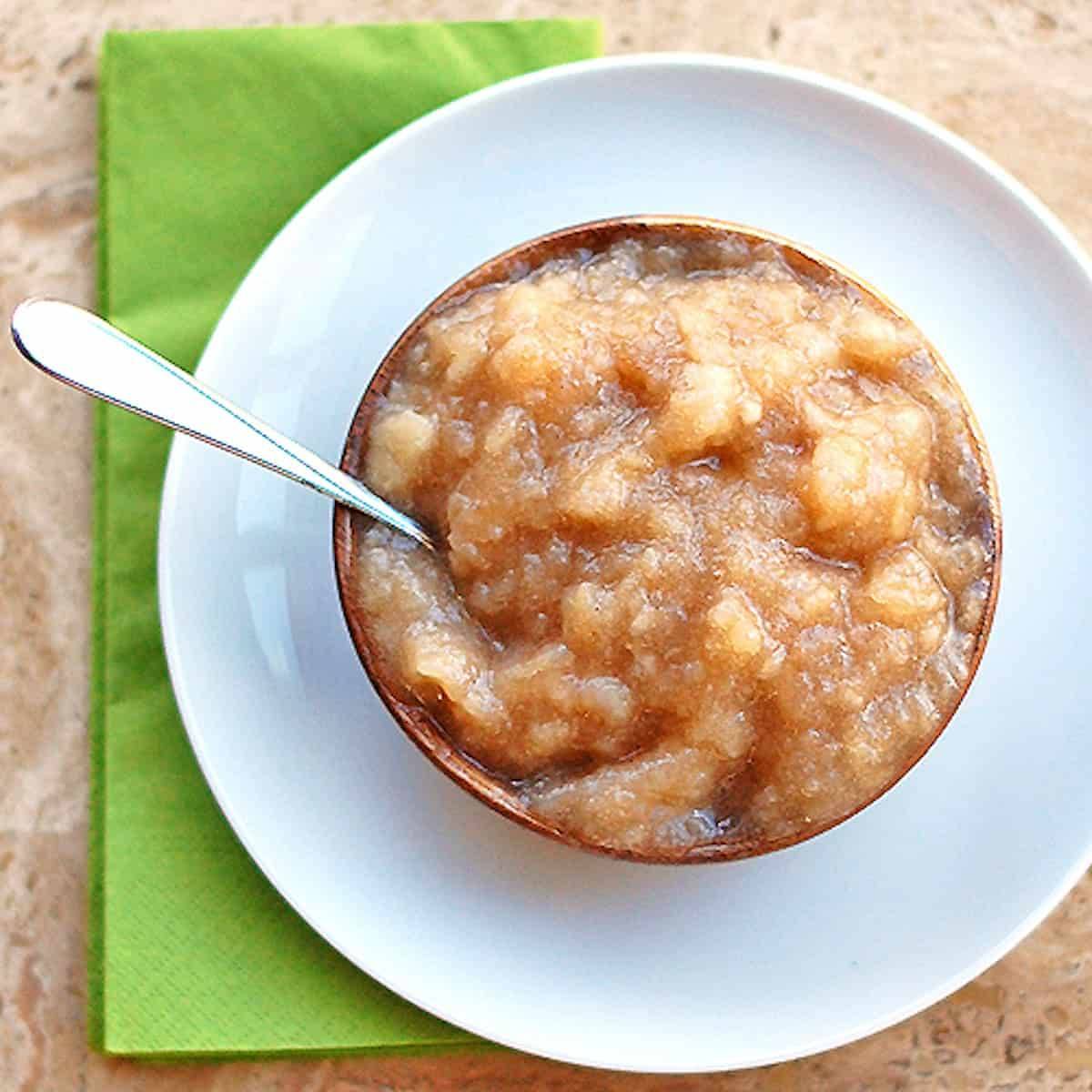 Homemade applesauce in a bowl on a green napkin.