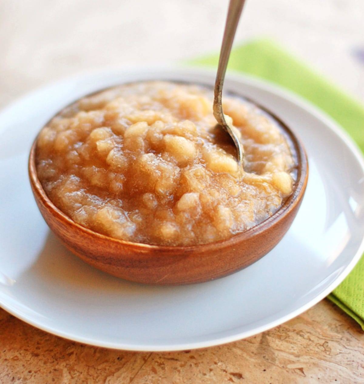 Homemade applesauce in a bowl with a spoon.