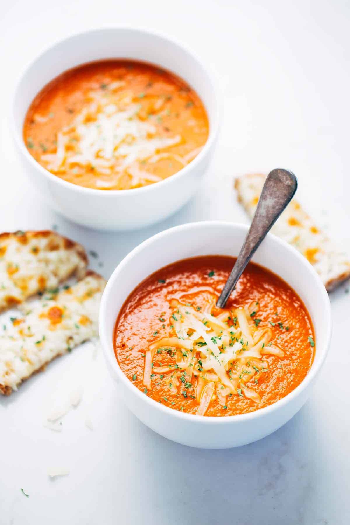 Homemade tomato soup in bowls with cheese.
