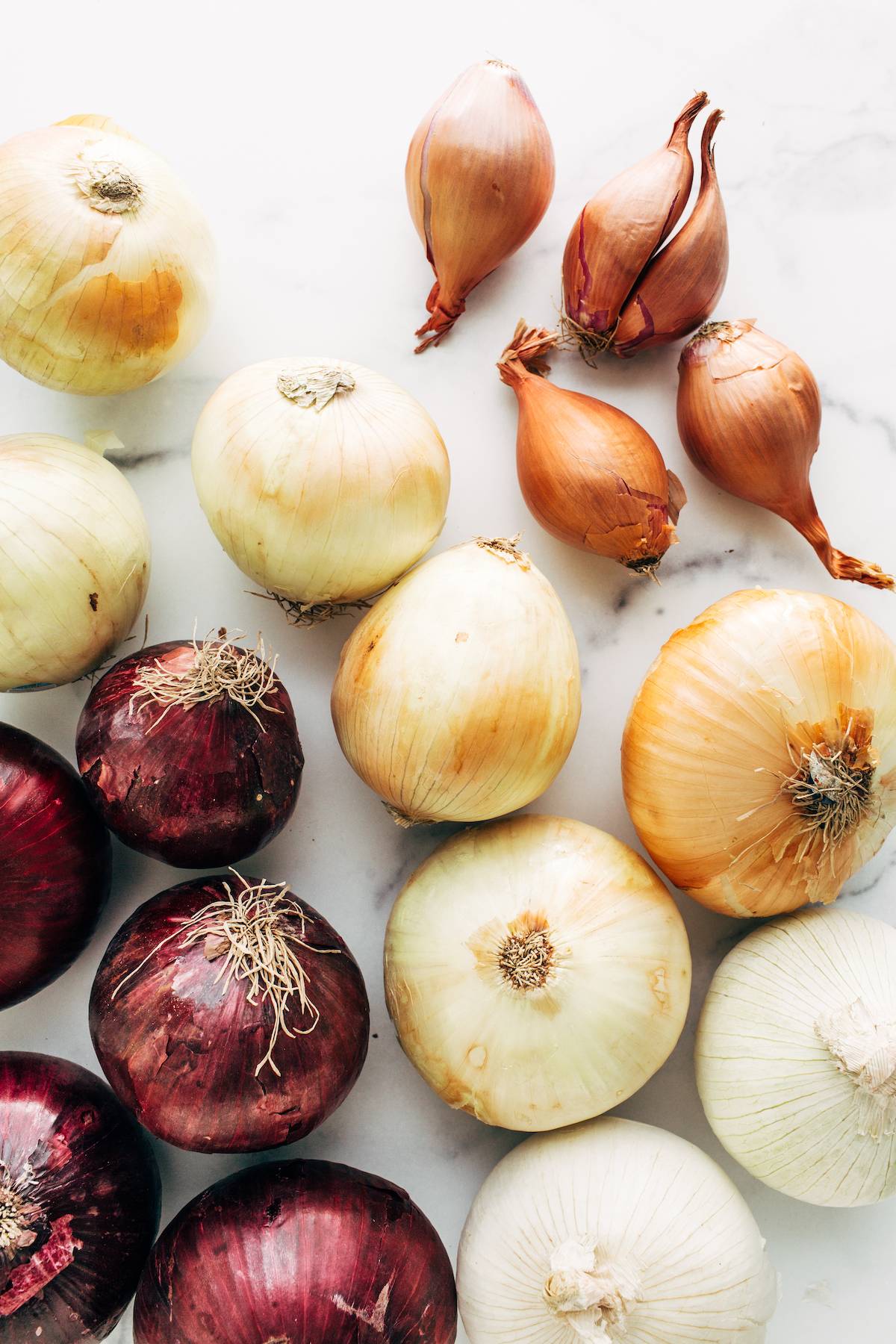Different onion varieties on a cutting board.