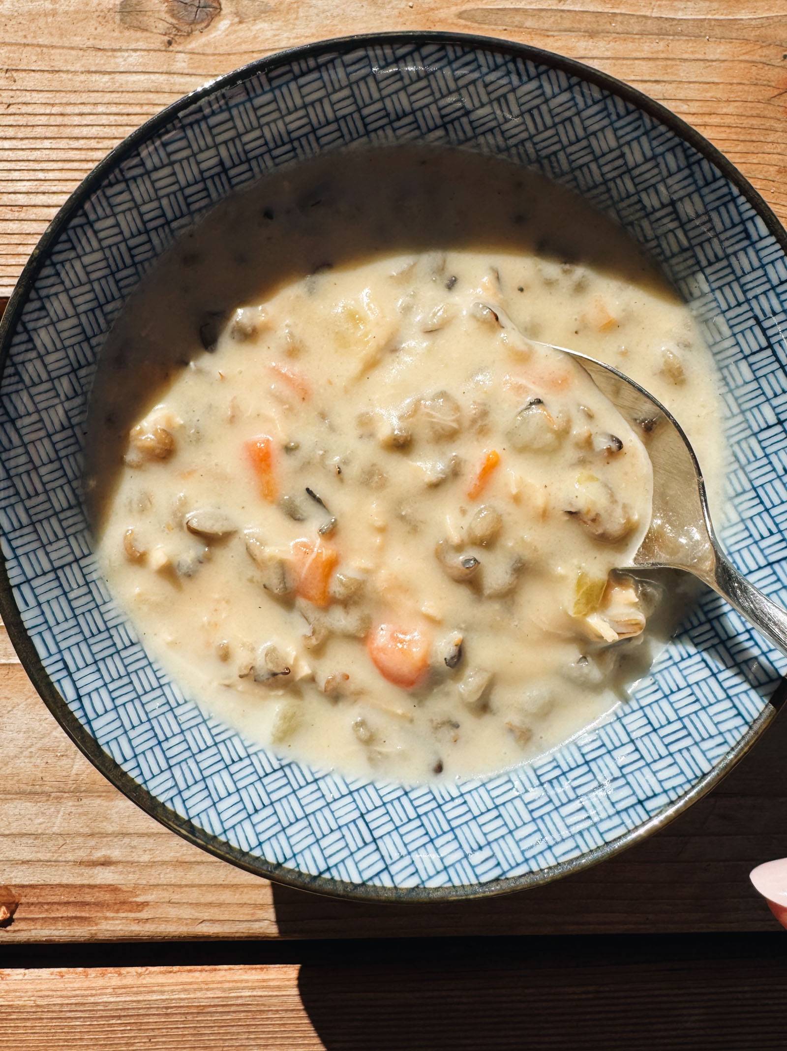 Wild rice soup in a bowl with a spoon.