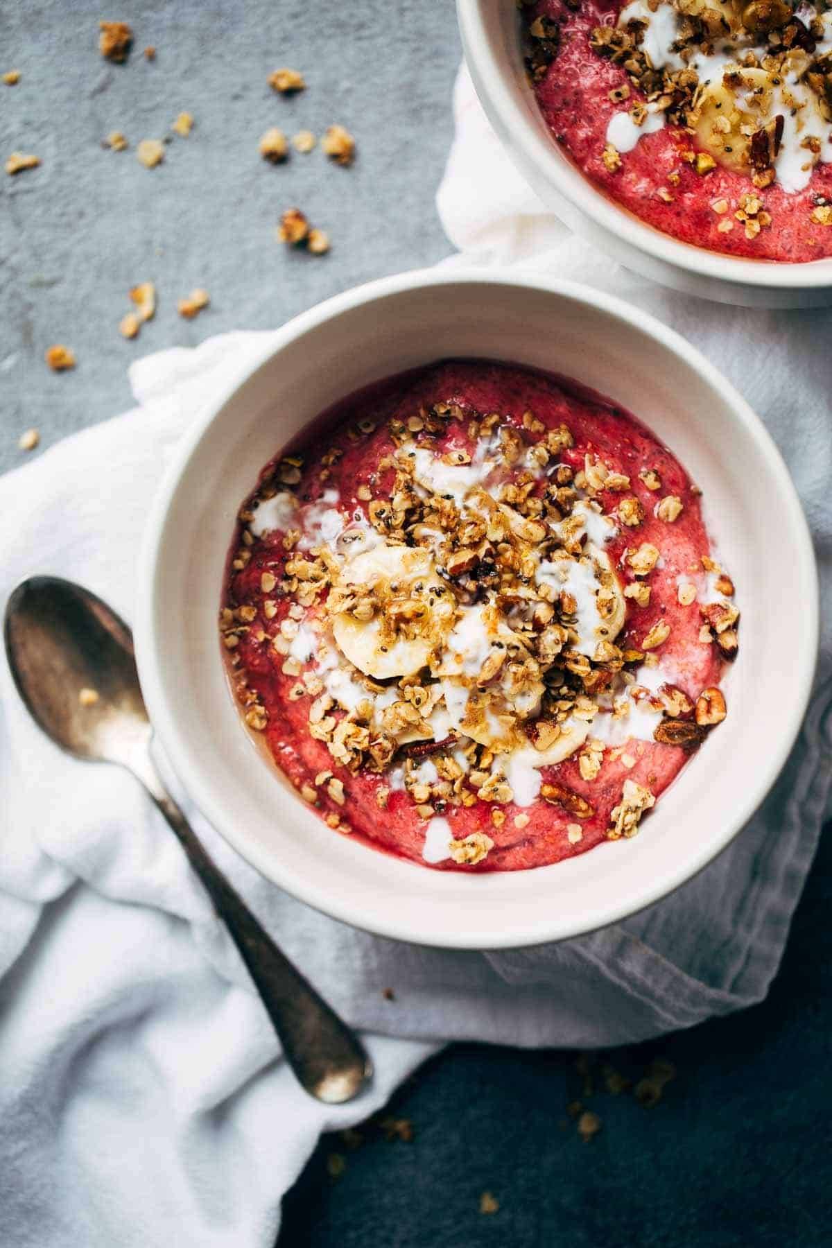 Raspberry Breakfast Bowls on a napkin with a spoon.