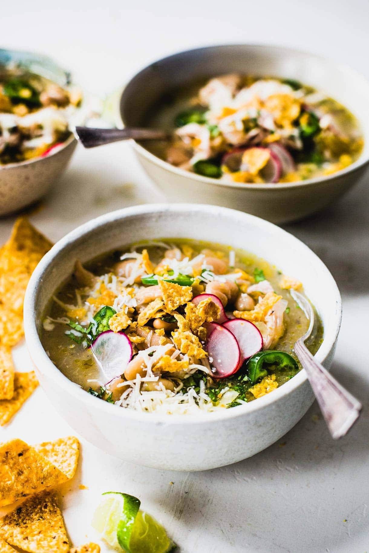 Jalapeño lime chicken soup in bowls with tortilla chips.