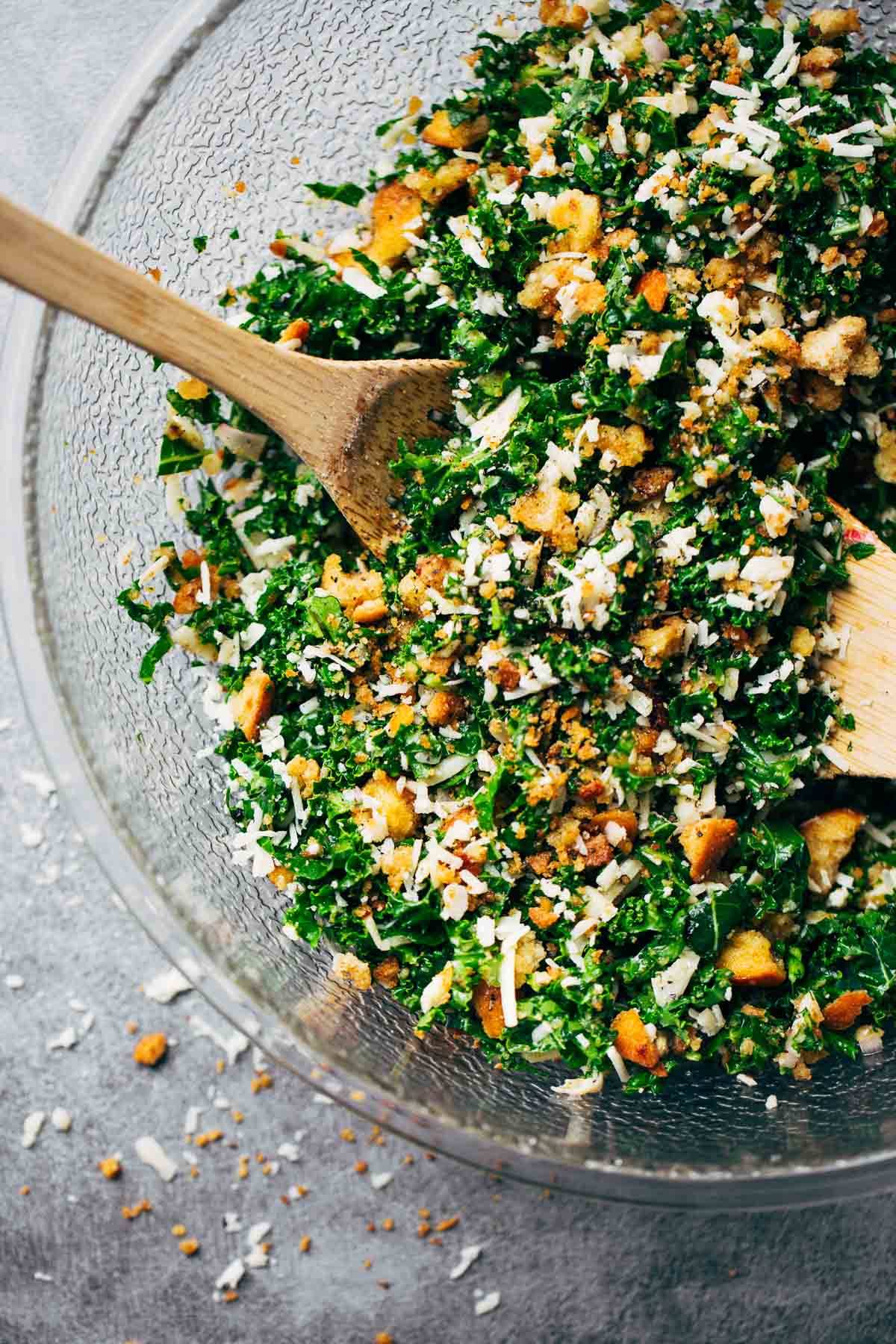 Kale salad in a clear mixing bowl.