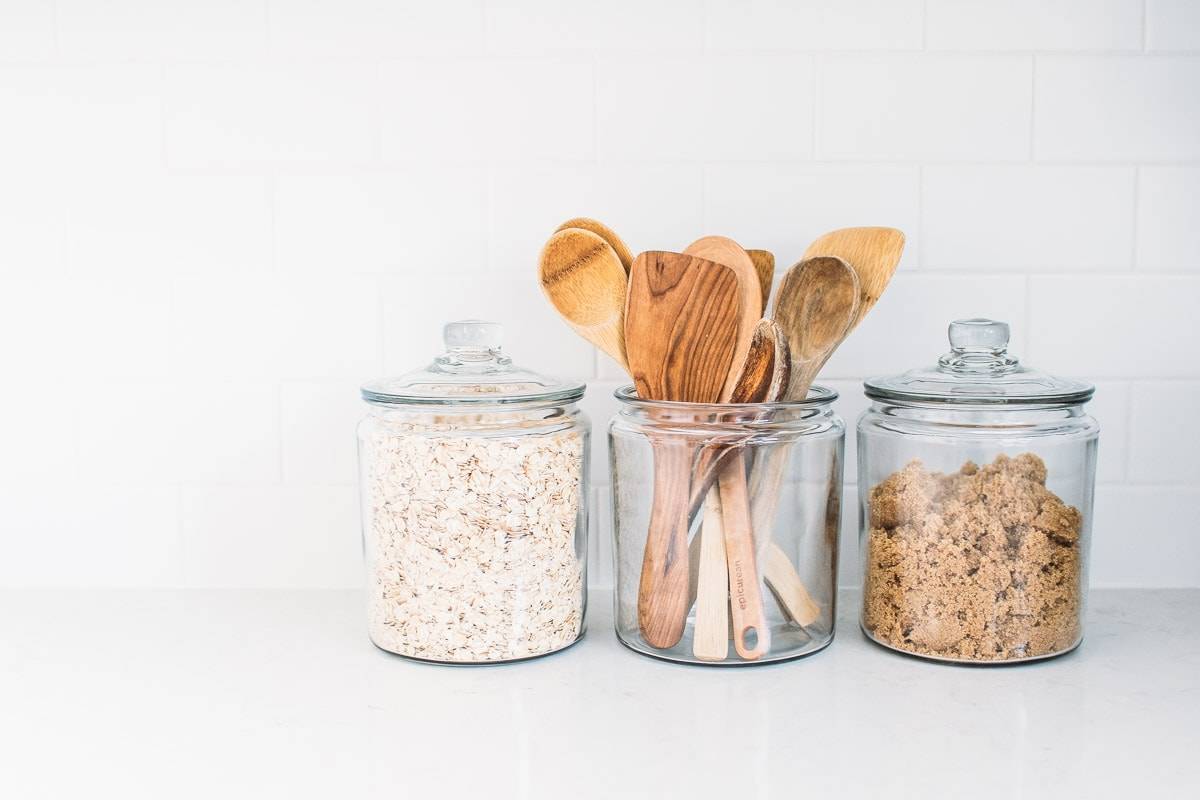 Clear containers with oats, wooden spoons, and sugar.