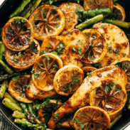 Asparagus and chicken with slices of lemon on it.