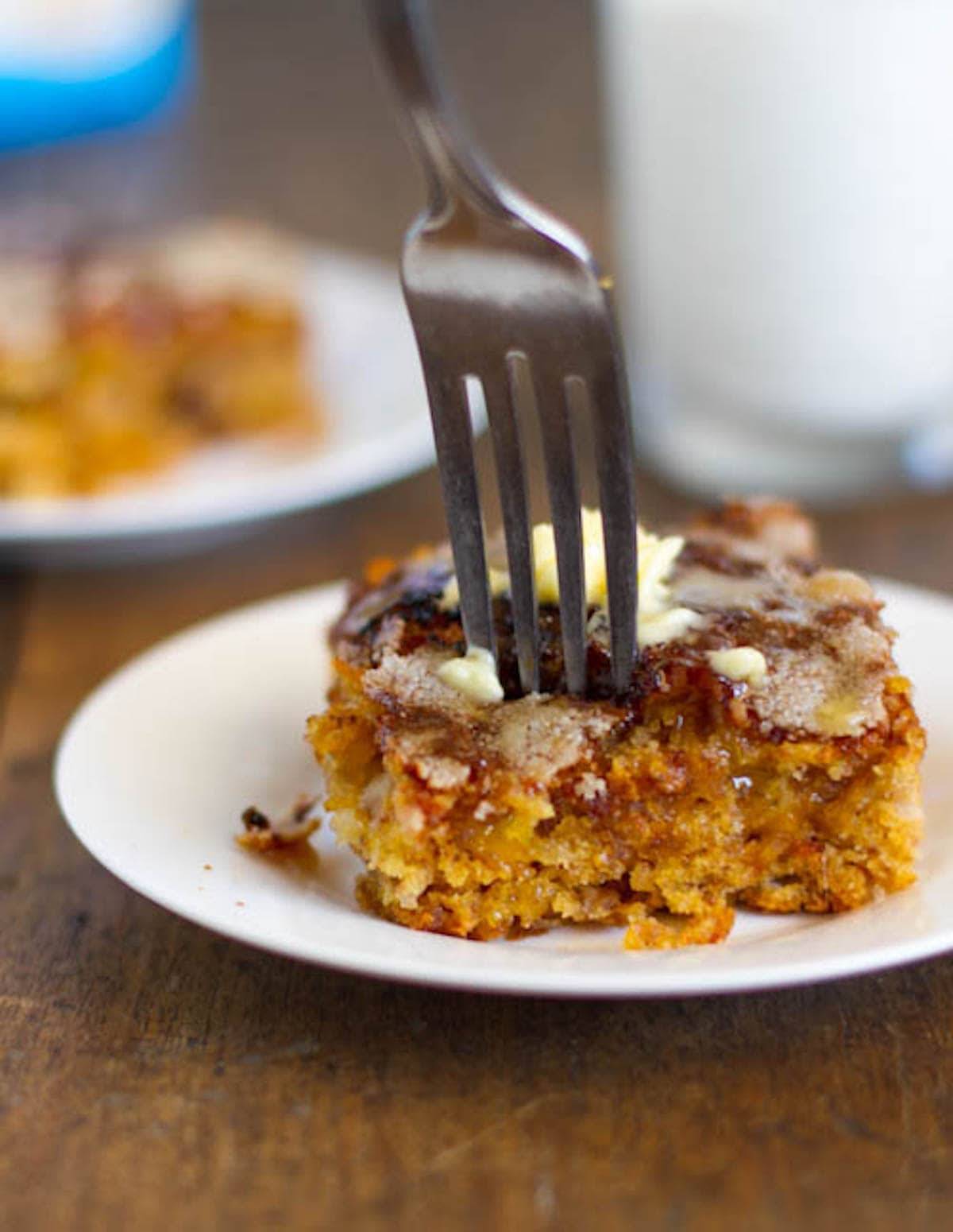 Fork in mango snack cake with a crunchy sugar topping.