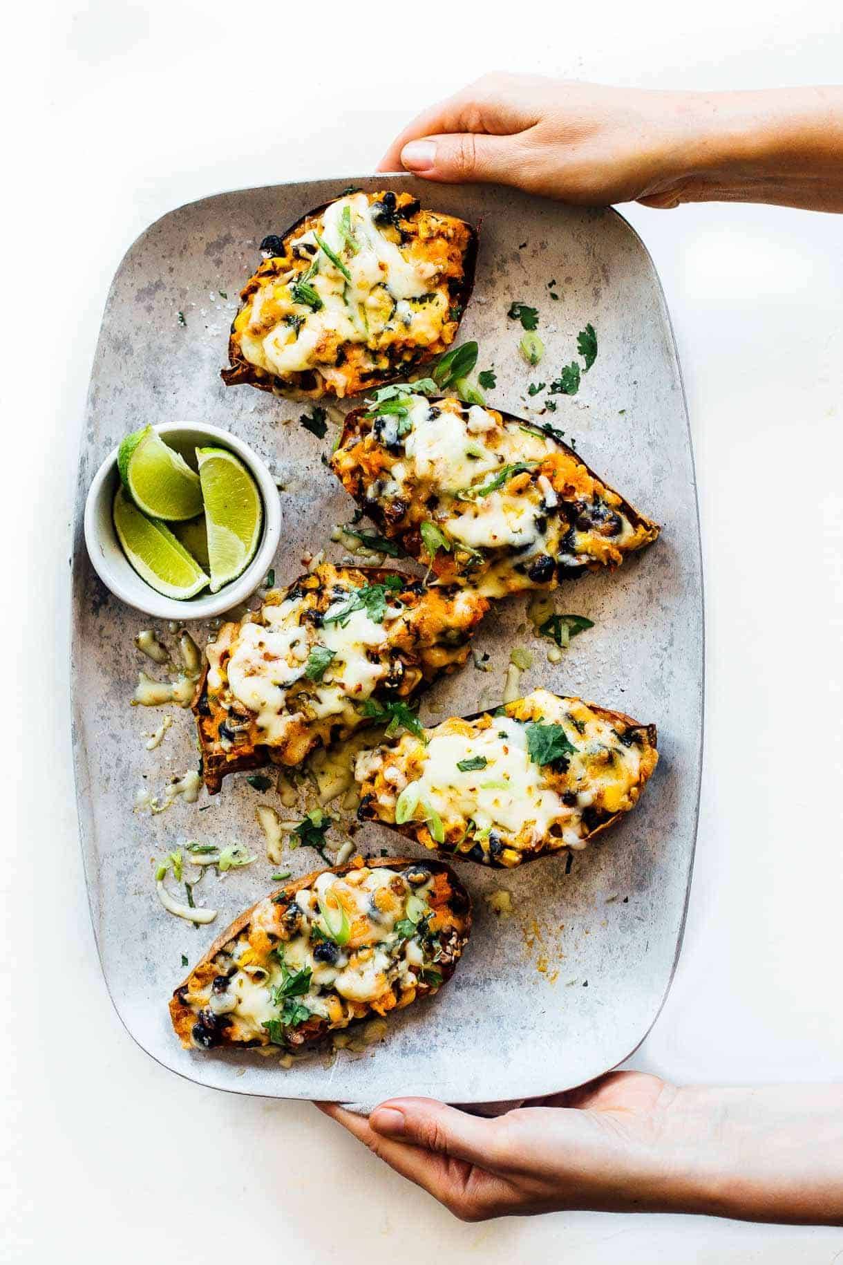 Chipotle sweet potato skins on a plate with limes.