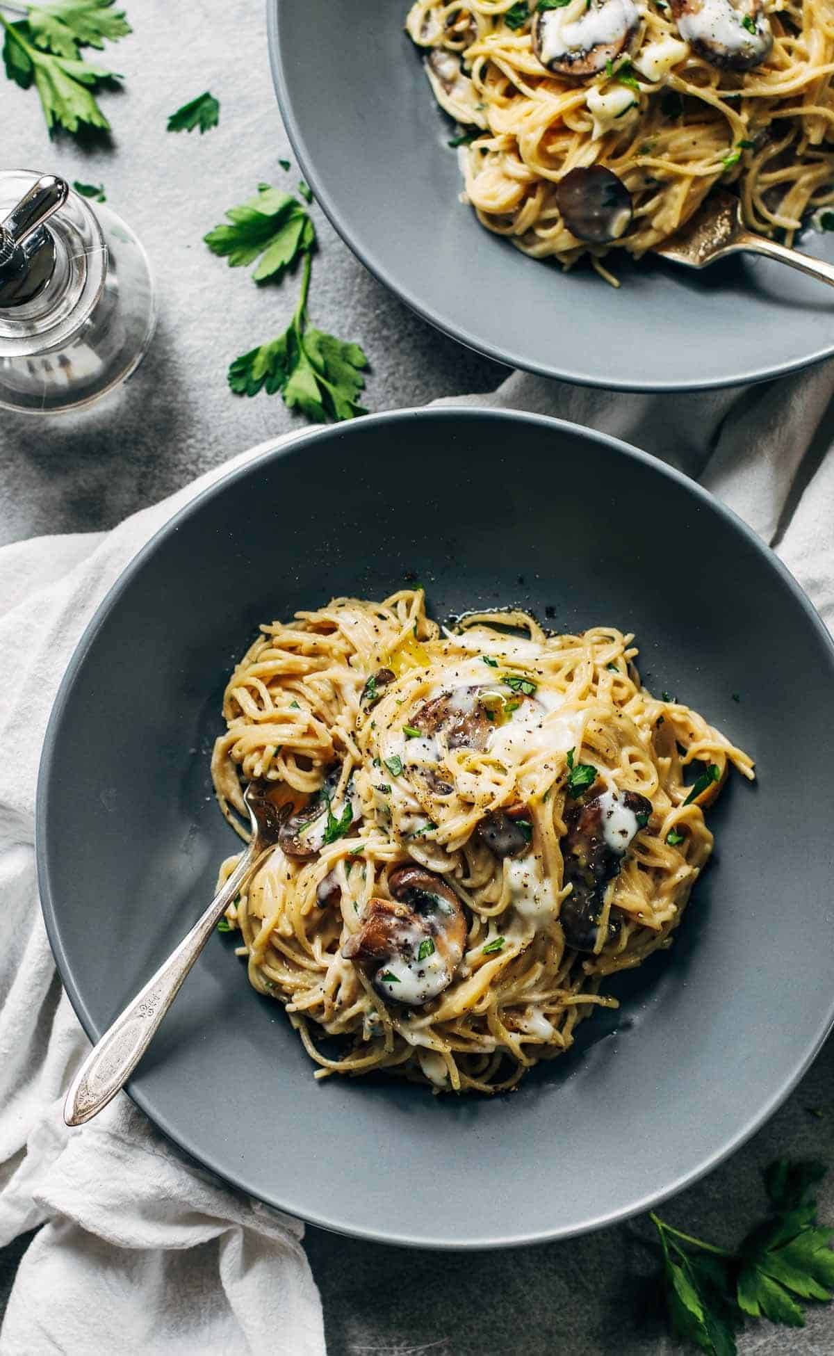 Creamy Garlic Herb Mushroom Spaghetti in two grey bowls.