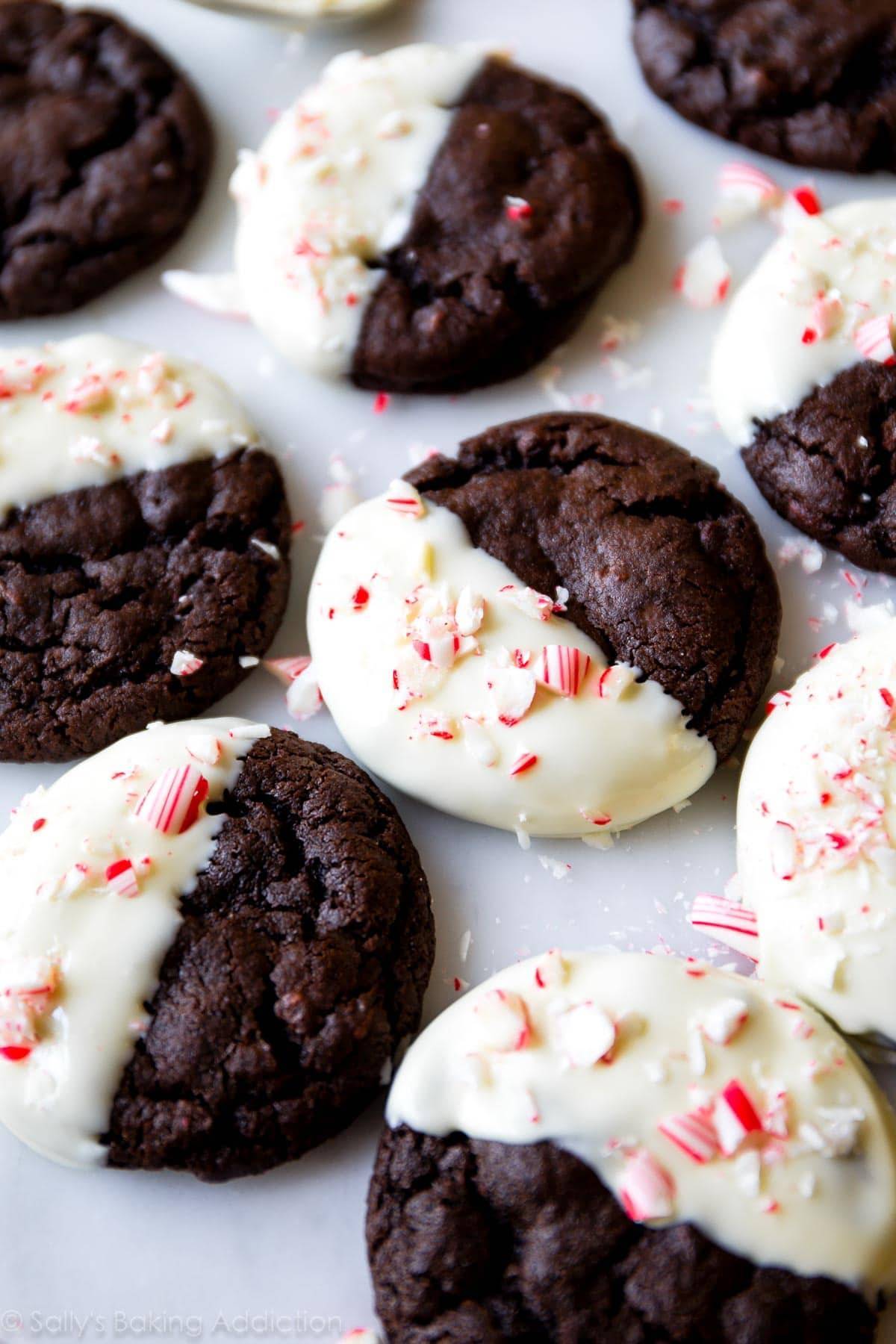 Chocolate cookies half frosted with peppermint on top.