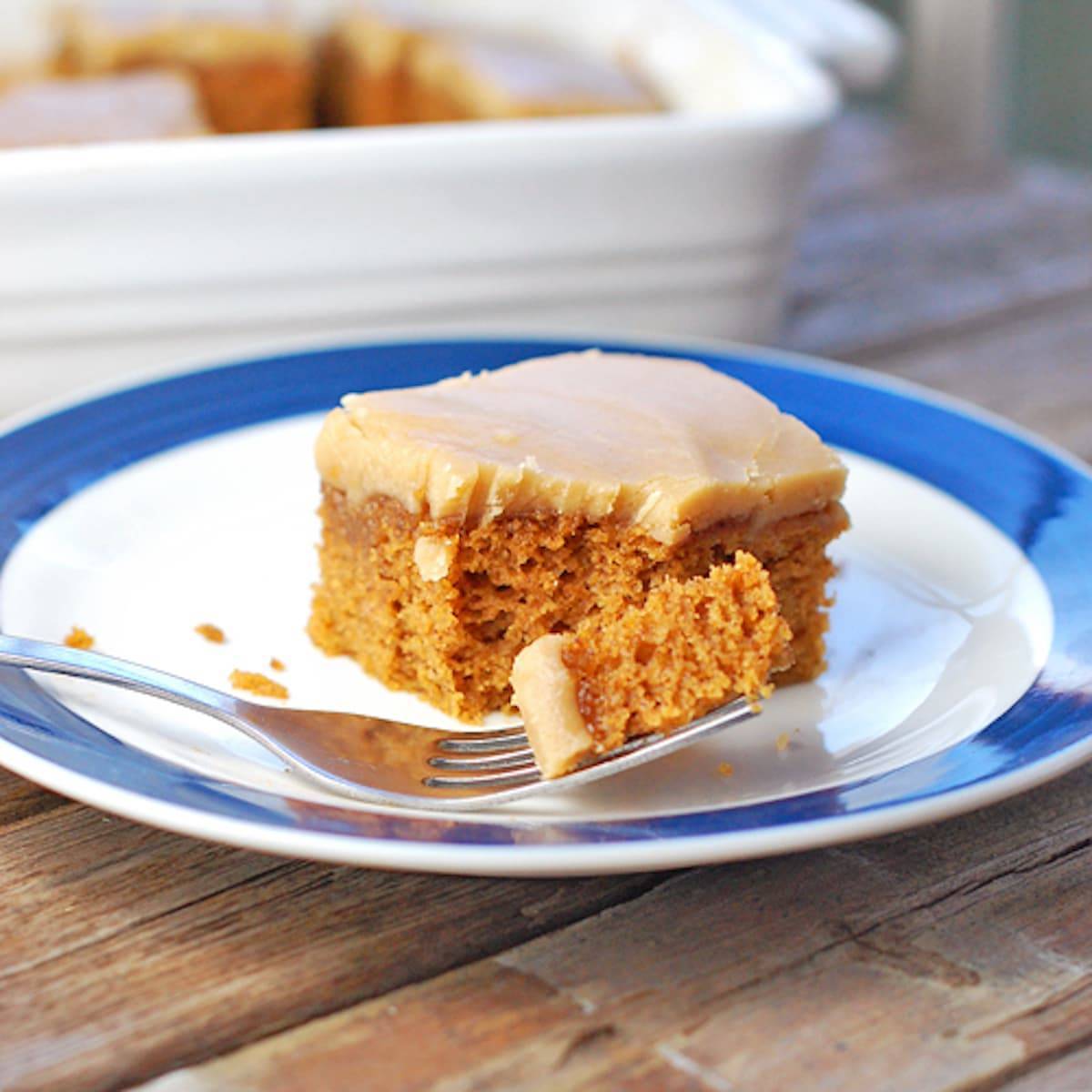 Pumpkin bars topped with this old-fashioned caramel frosting on a blue and white plate.