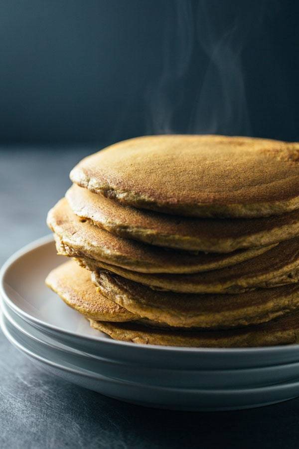 Pancakes stacked on three plates.