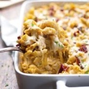 Chicken Bacon Pumpkin Pasta Bake bring pulled out of pan with a spoon.