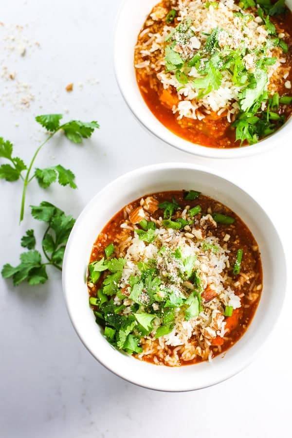 Soup in two bowls with herbs.