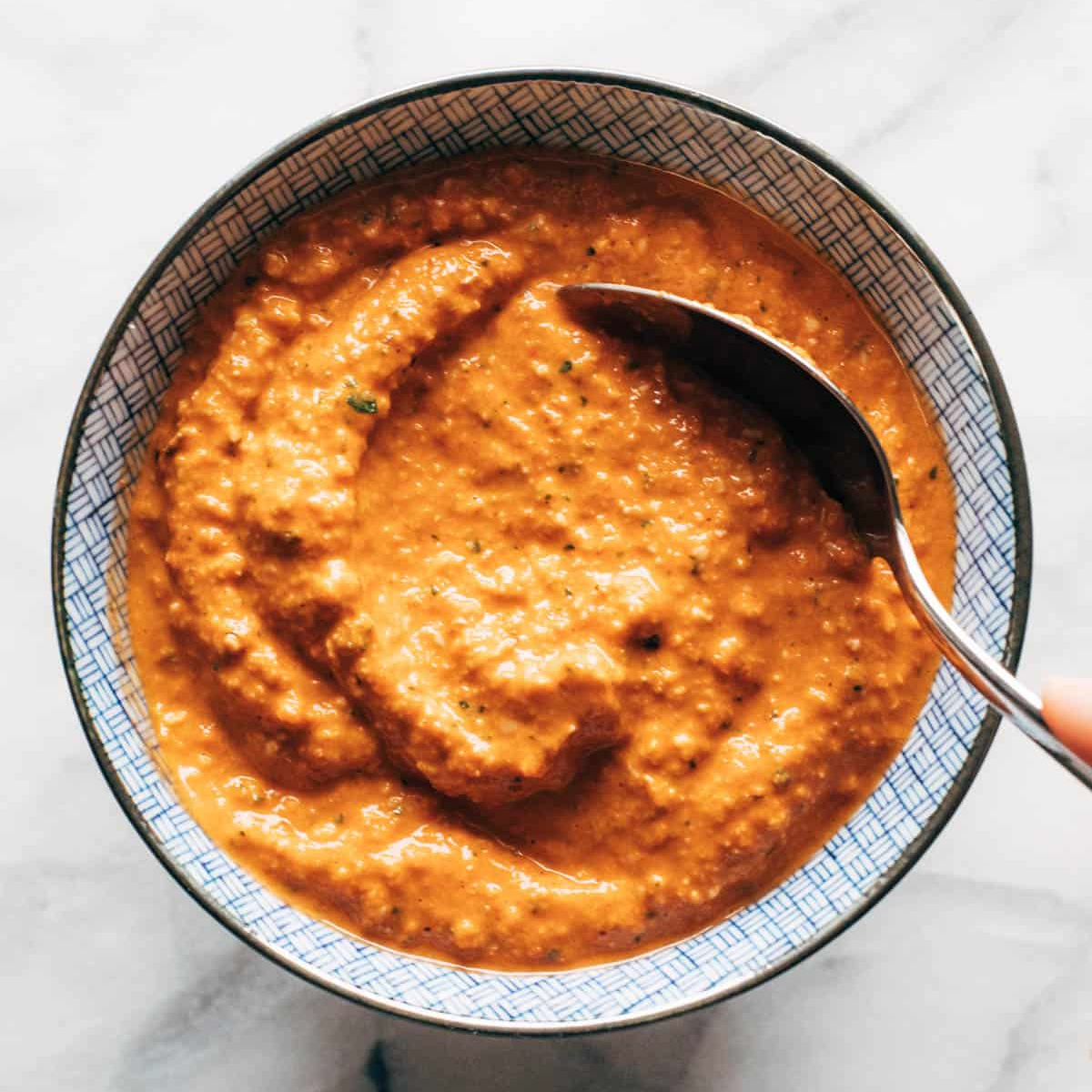 Romesco sauce in a bowl with a spoon.