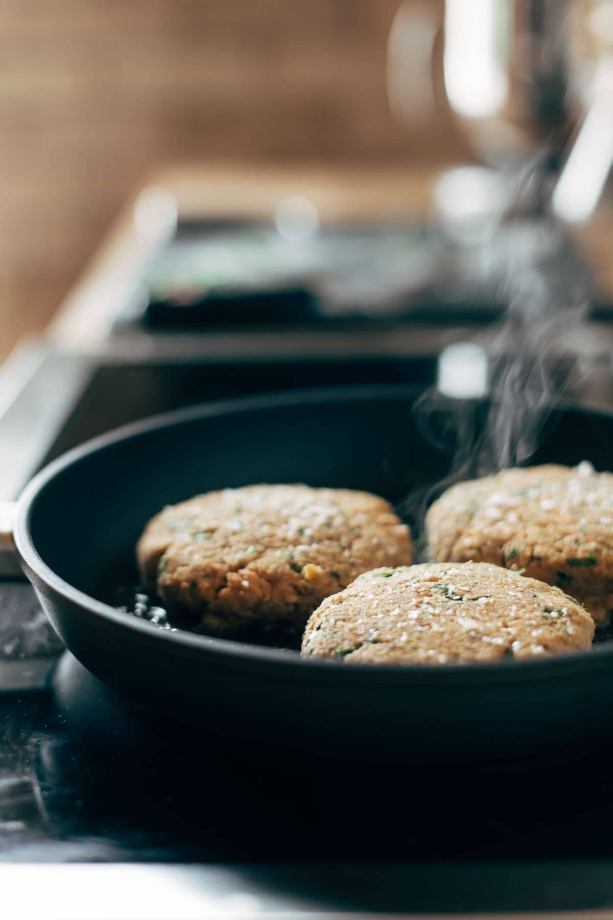Cooking salmon burgers in pan.
