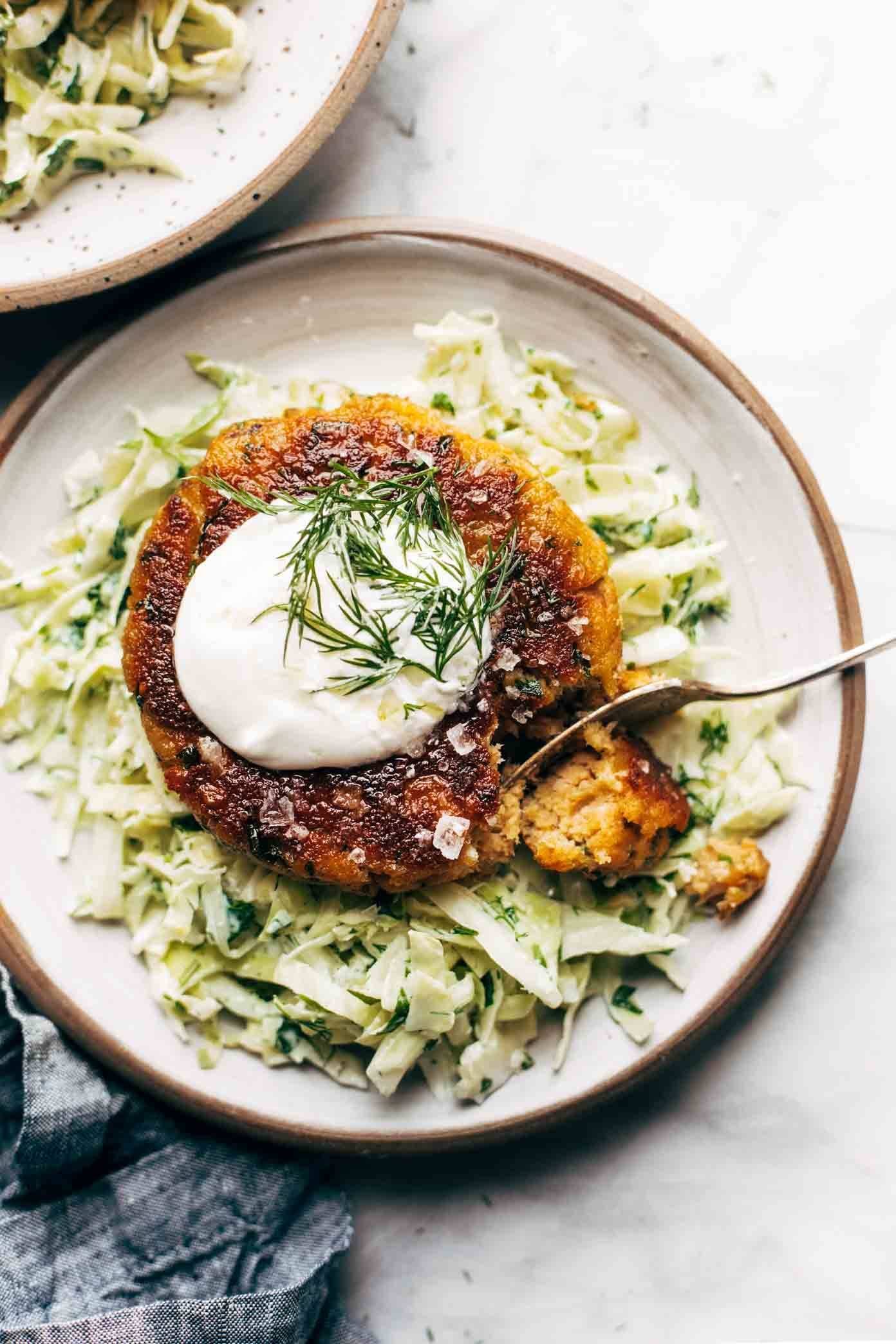 Salmon burger on a bed of cabbage with a dollop of yogurt on top.