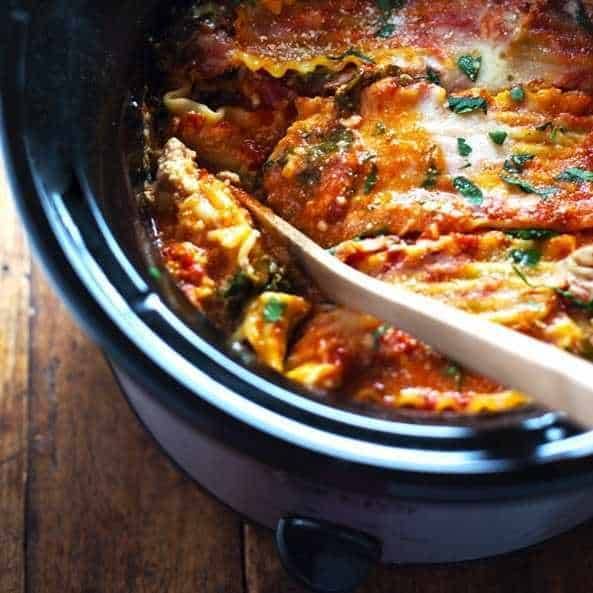 A pot of lasagna with a spoon in it.