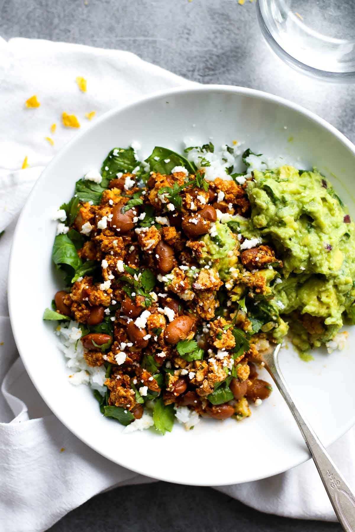 Sofritas in a bowl with rice and guacamole.