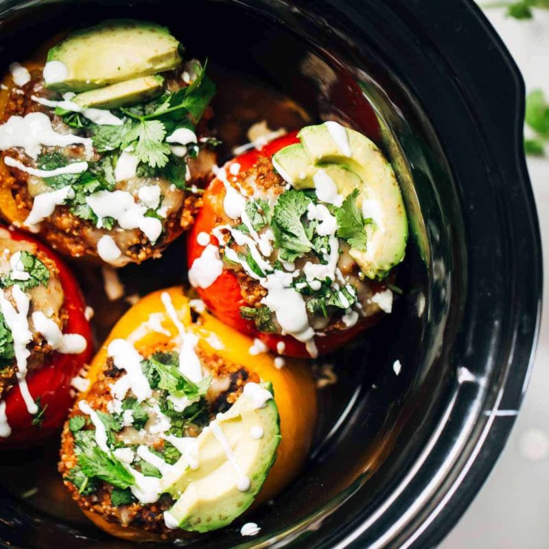 Stuffed Quinoa peppers and avocado slices in a crockpot.