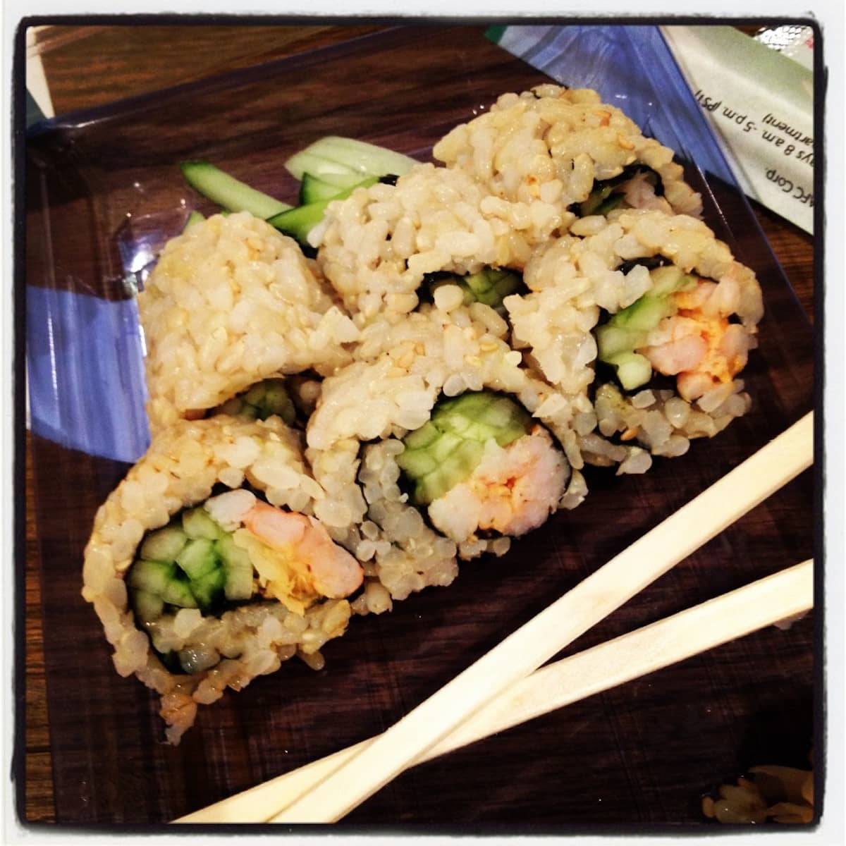 Brown Rice Sushi on a platter with chopsticks.