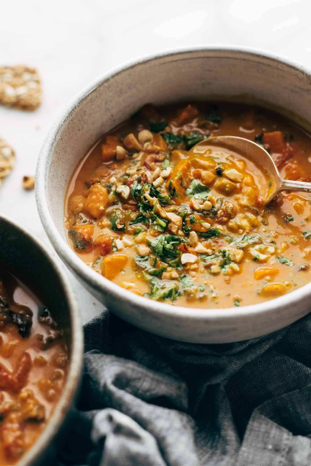 A spoon in a bowl of Spicy Sweet Potato Peanut Stew.