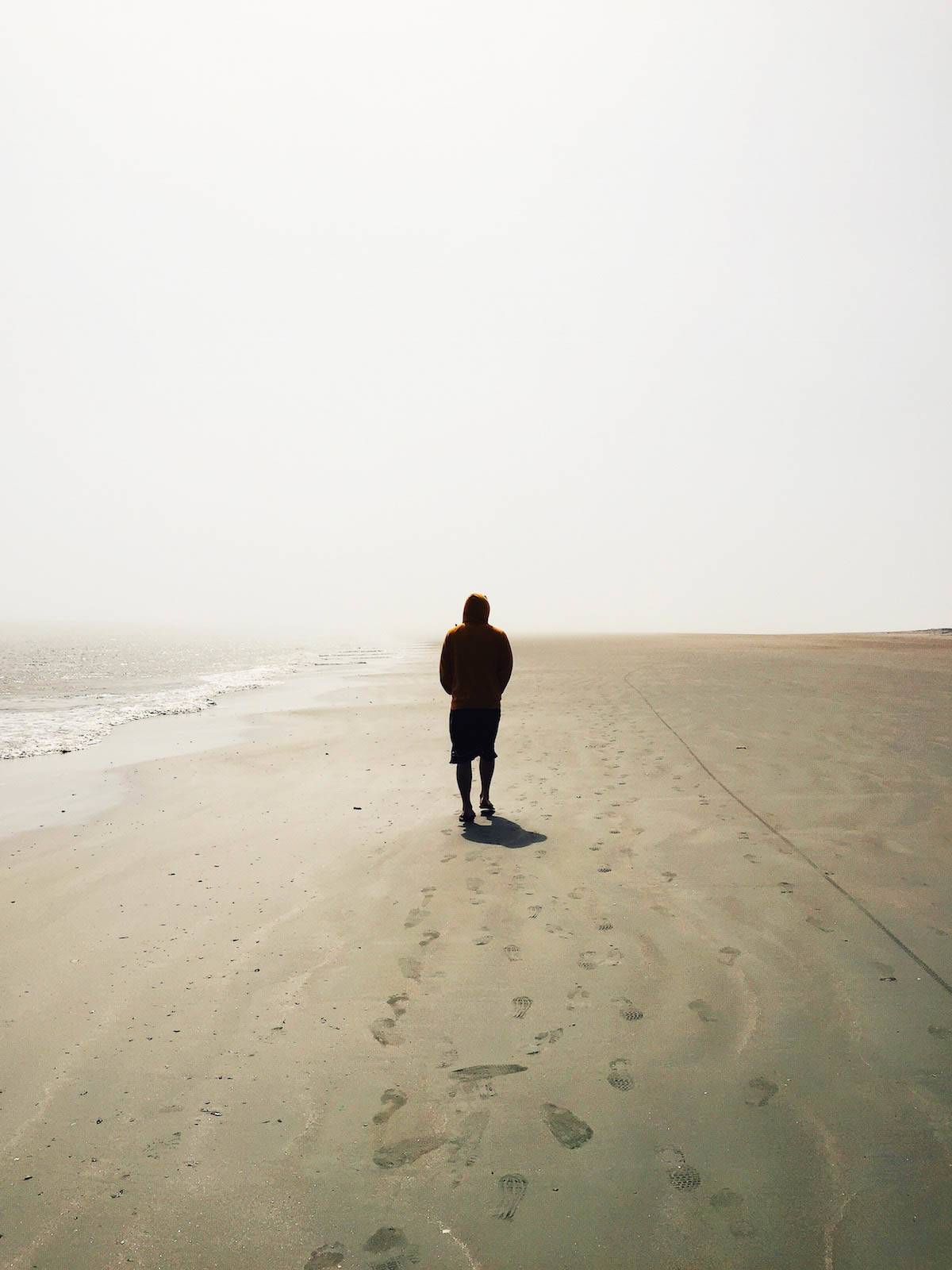 Pria berjalan di pantai.