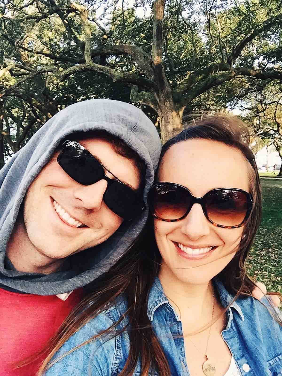 Man and woman smiling with sunglasses.