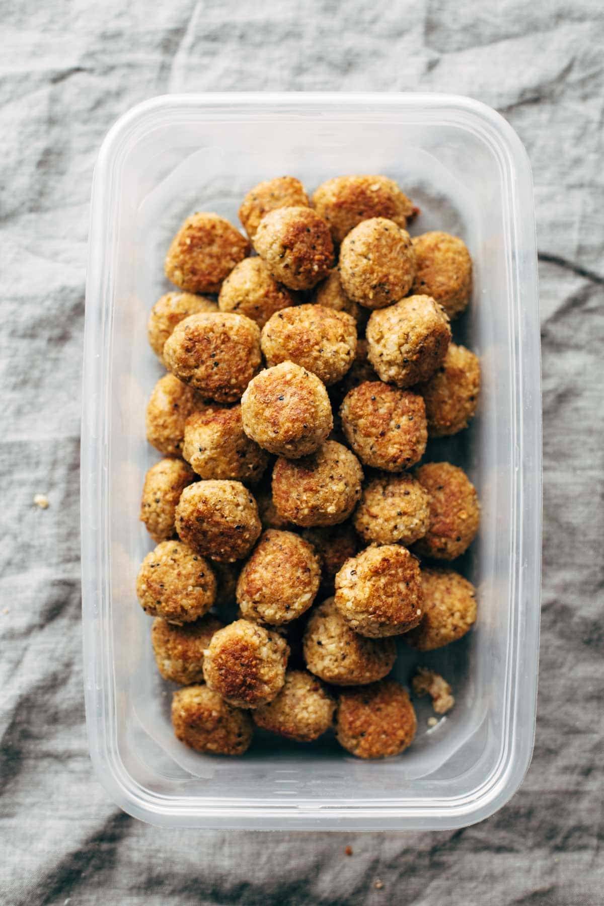 Cauliflower vegetarian meatballs stacked in a container.