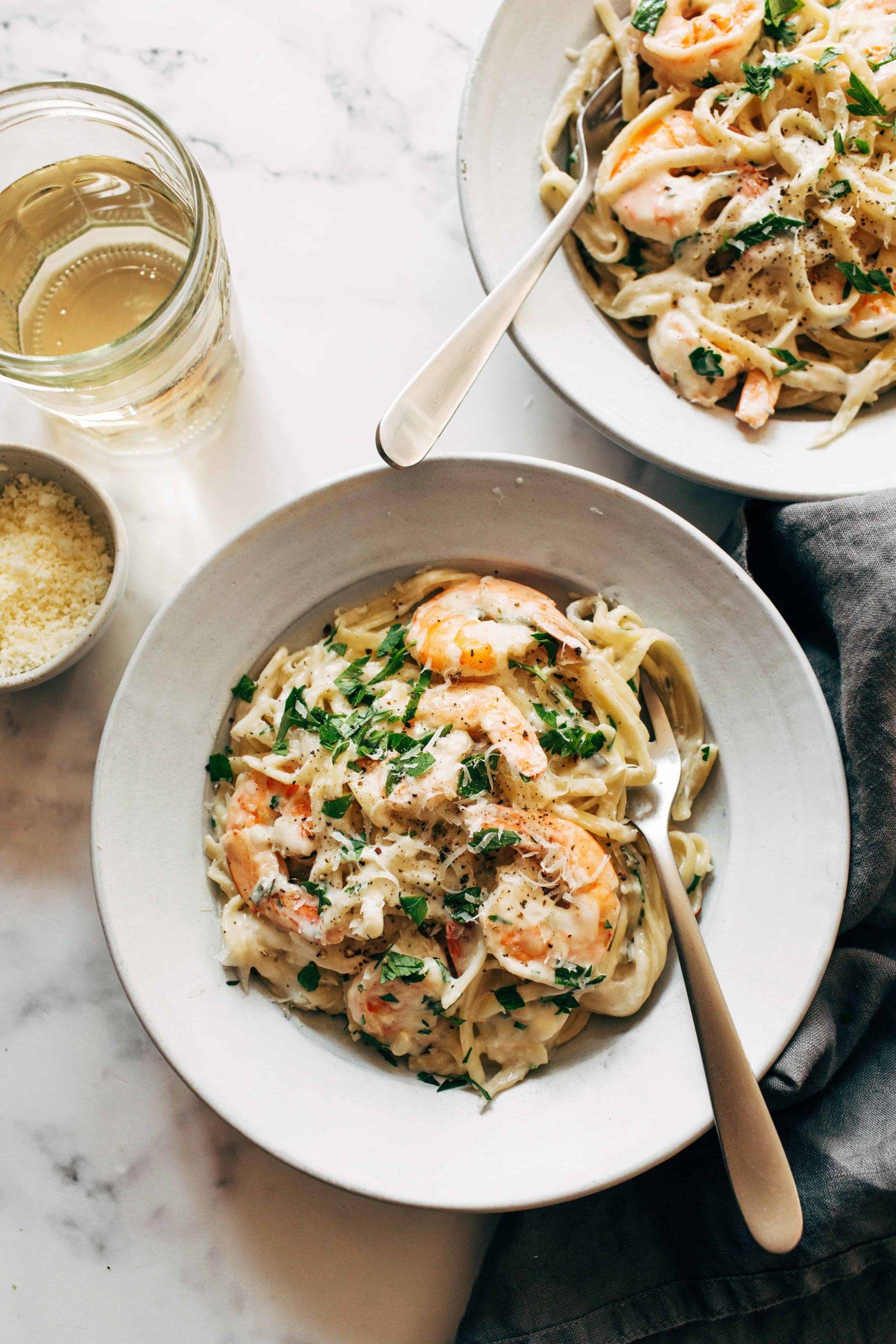 Two bowls of shrimp linguine with white wine.