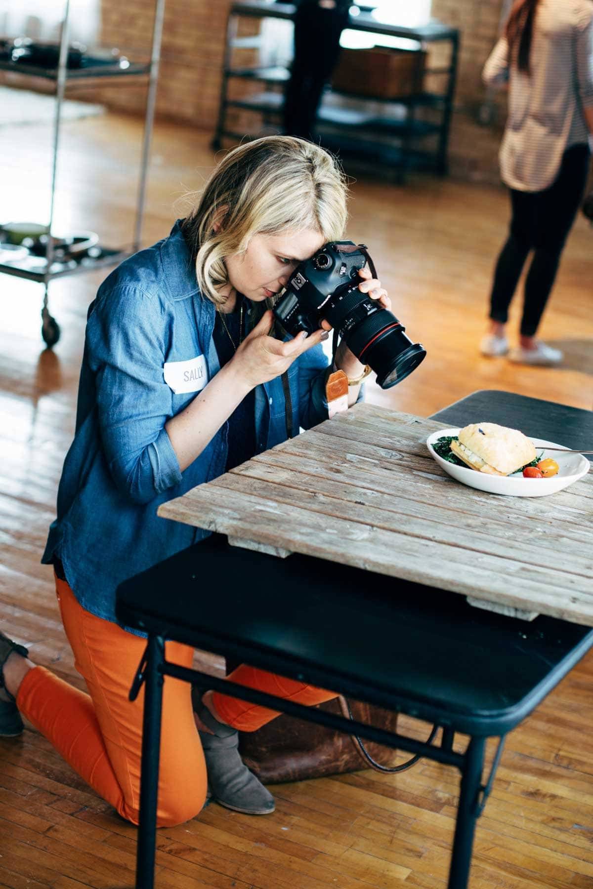 Woman photographing food with a camera.