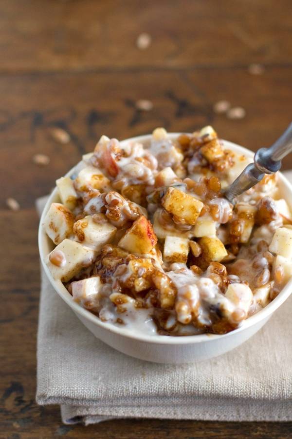 Yogurt parfaits with brown sugar, apples, wheat berries, flax, and walnuts in a bowl.